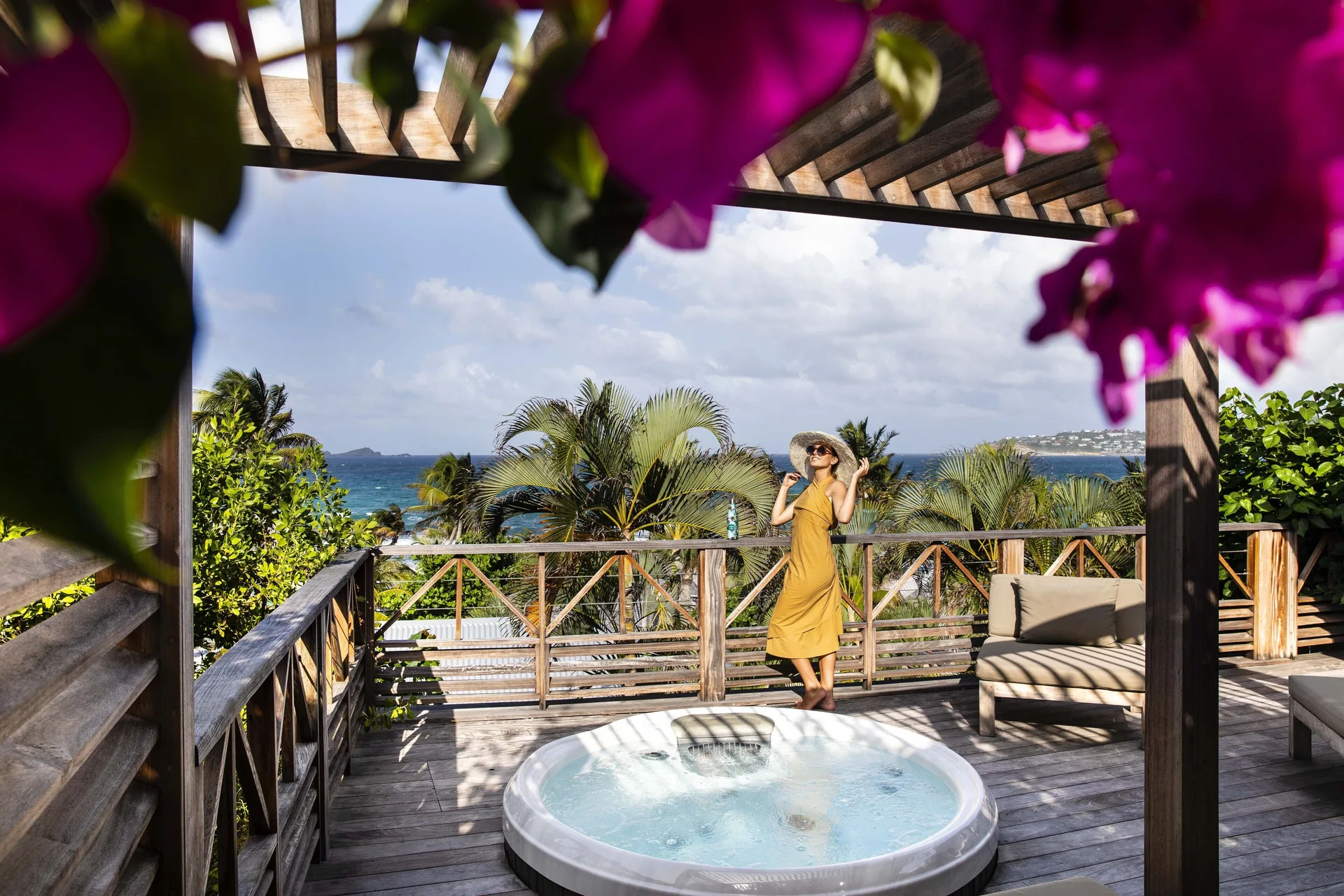 Suite terrace jetted tub with ocean view and palms at Hotel Manapany.