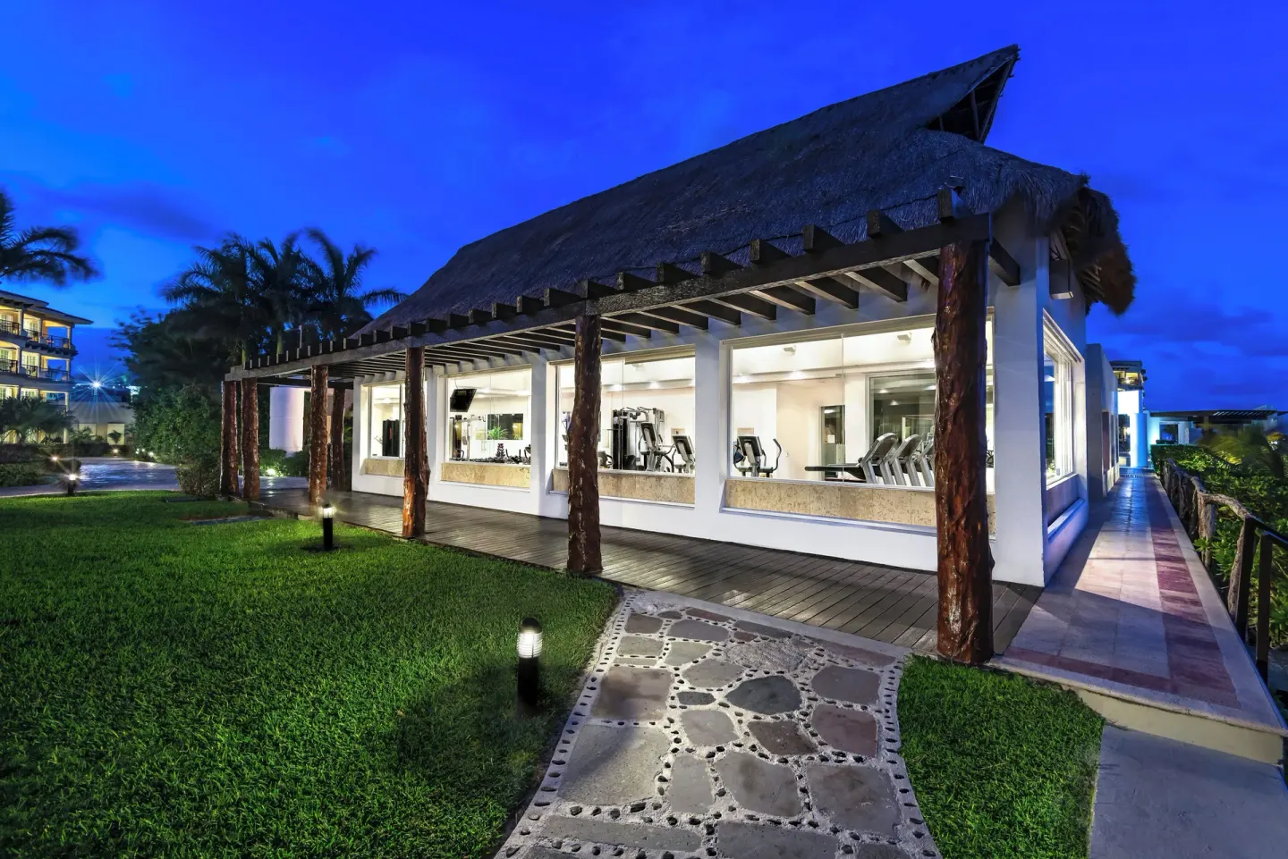 Exterior of the fitness center at dusk at Hotel Marina El Cid Spa & Beach Resort.