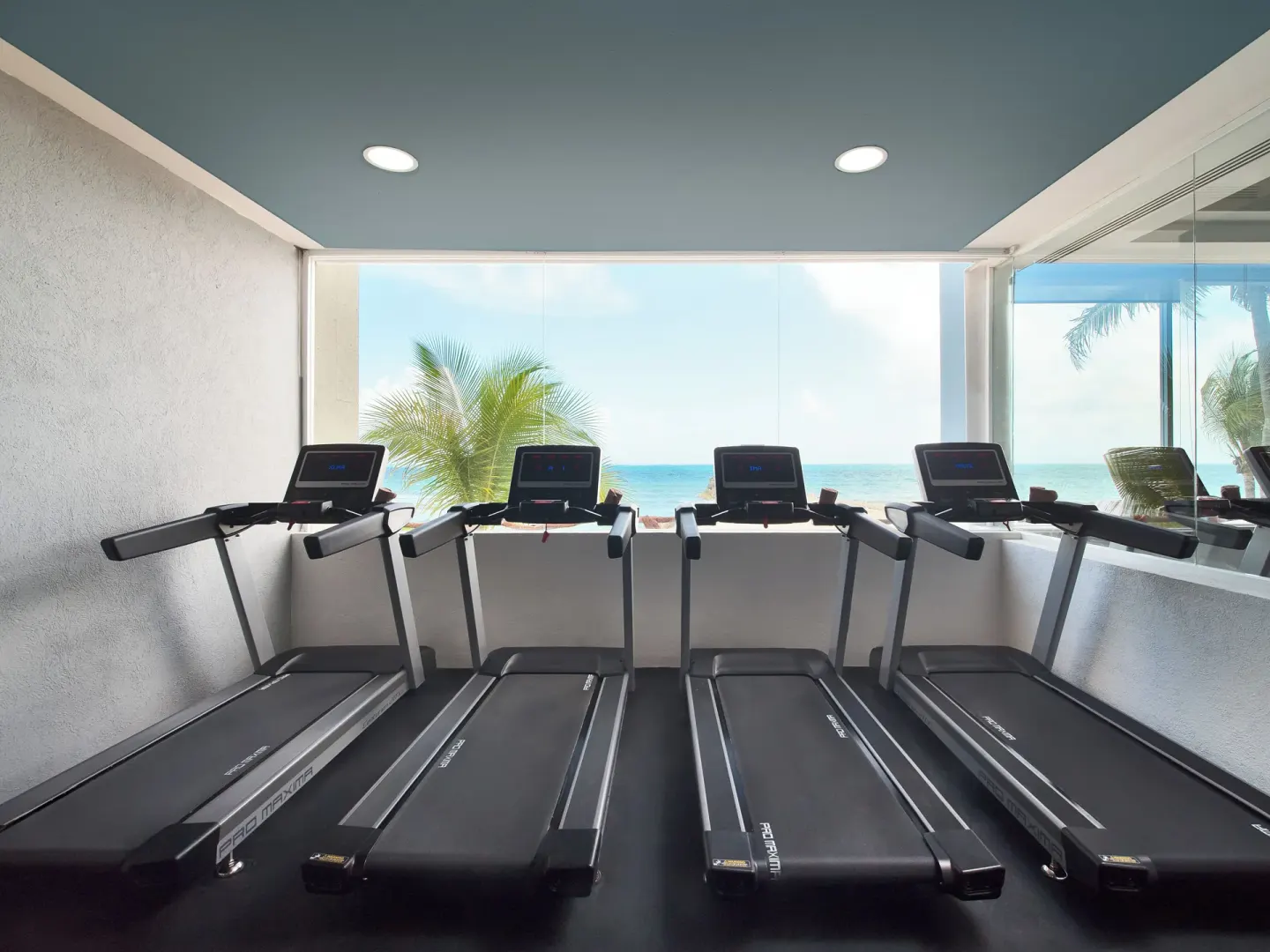 Treadmills overlook the ocean in the fitness room at Hotel Marina El Cid Spa & Beach Resort.