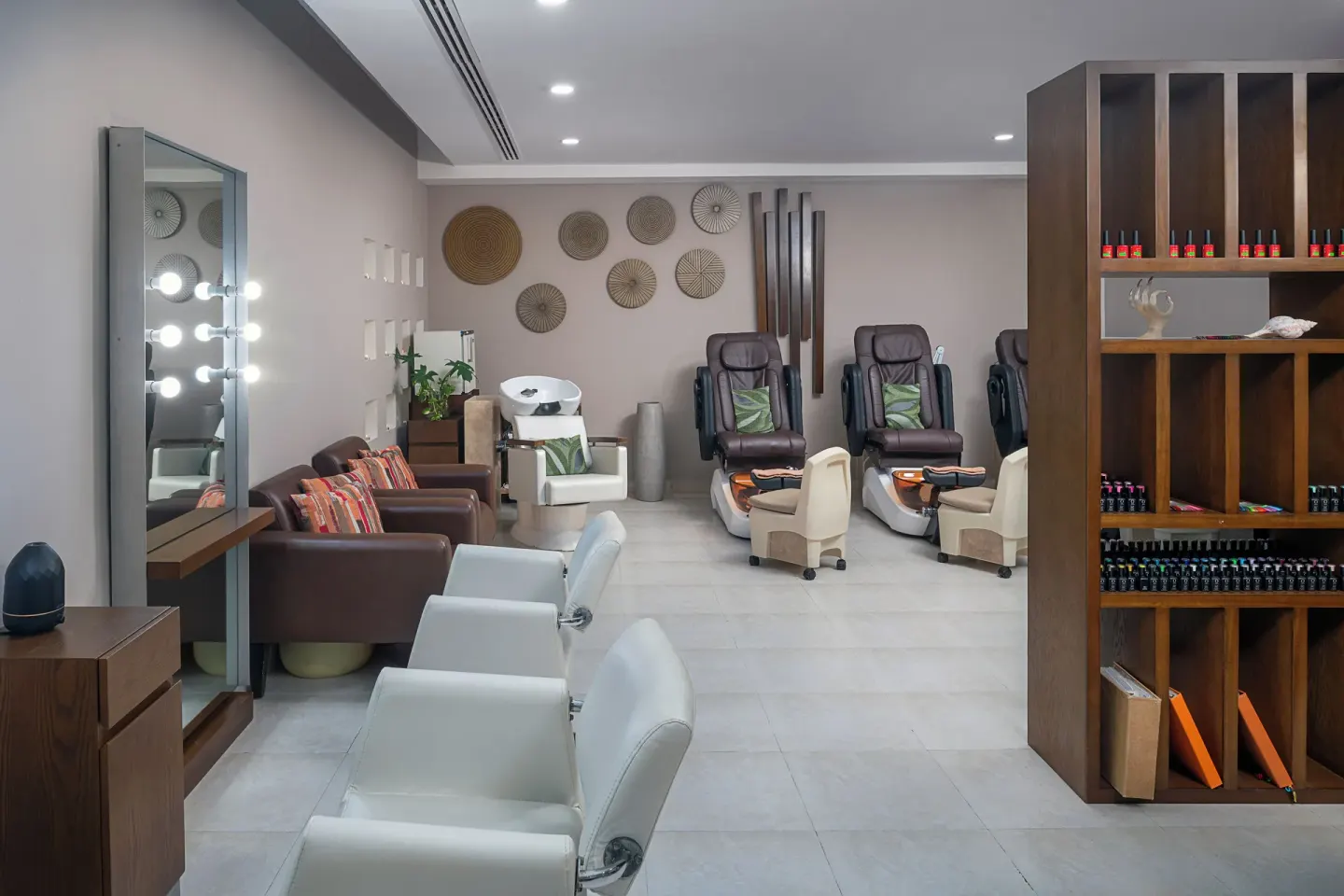 A salon area with styling chairs, pedicure seats, and product shelves at Hotel Marina El Cid Spa & Beach Resort.