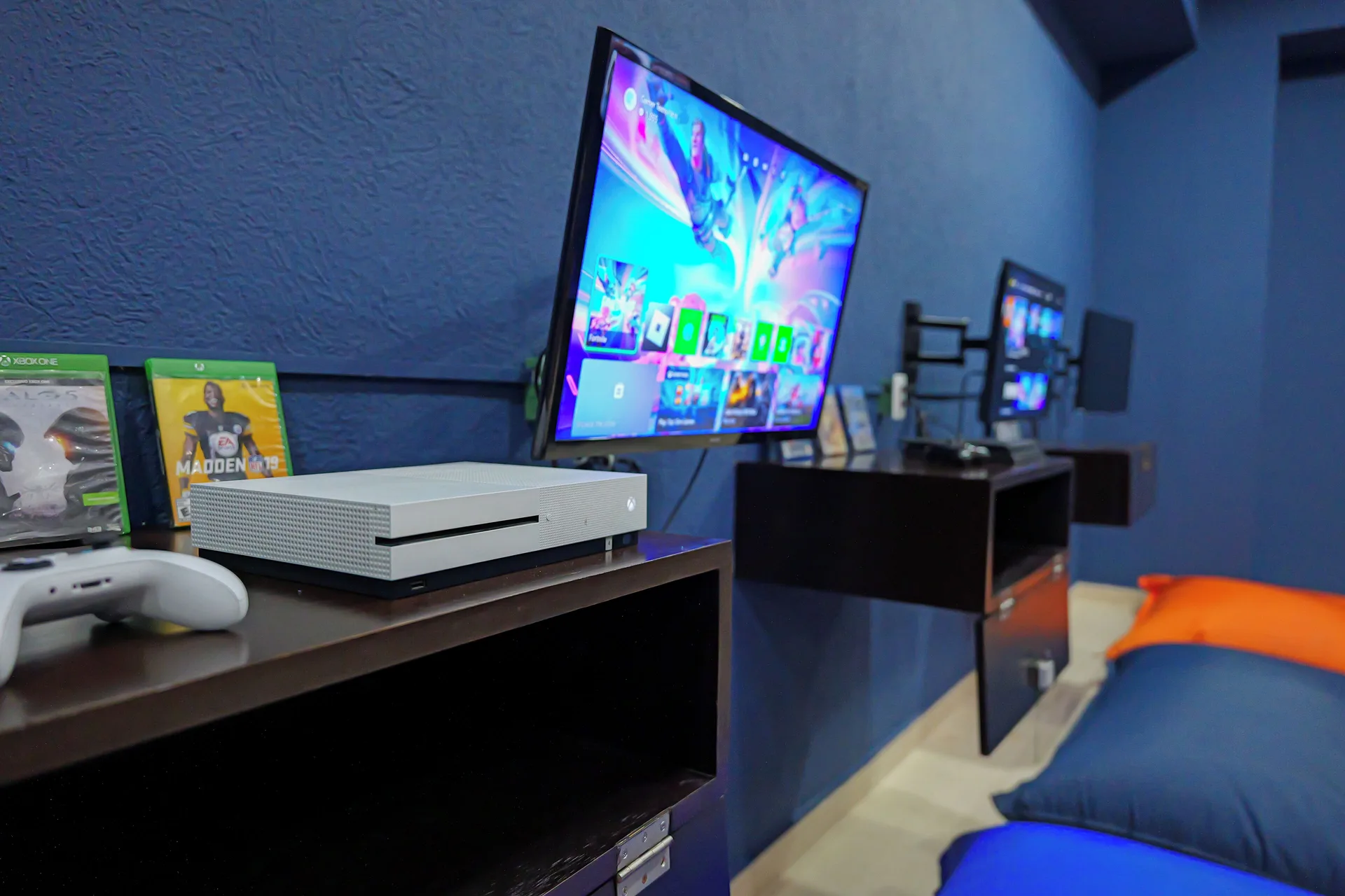Video game stations line a blue-walled room at Hotel Marina El Cid Spa & Beach Resort.