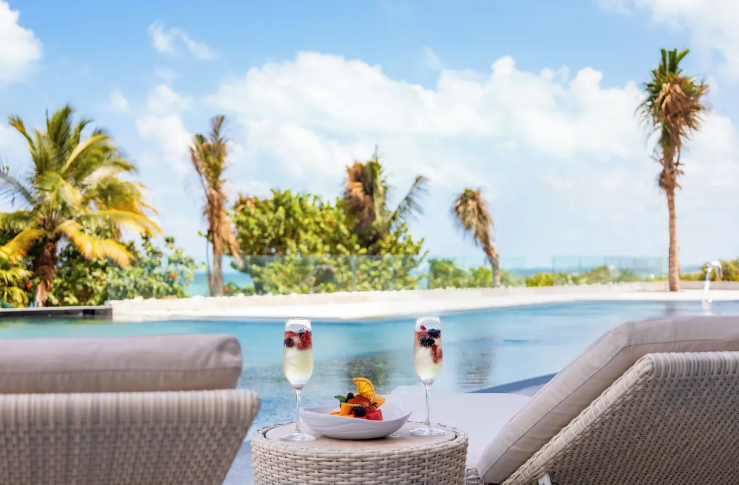 Poolside loungers with fruit and sparkling drinks at Hotel Mousai Cancun.