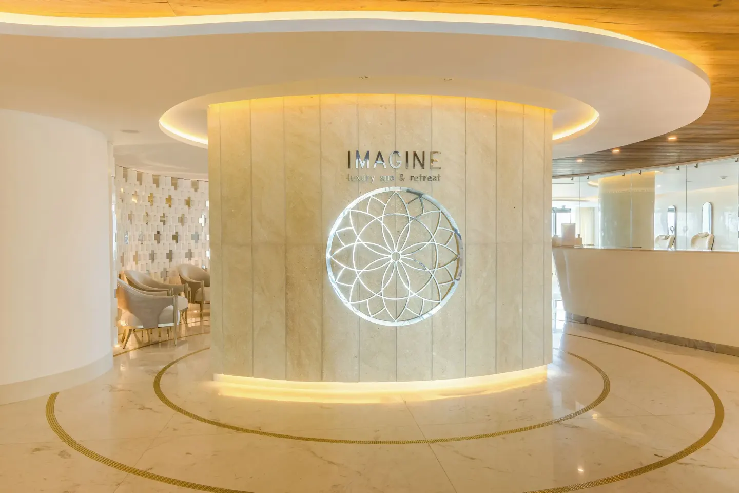 Spa reception wall with illuminated decorative emblem at Hotel Mousai Cancun.