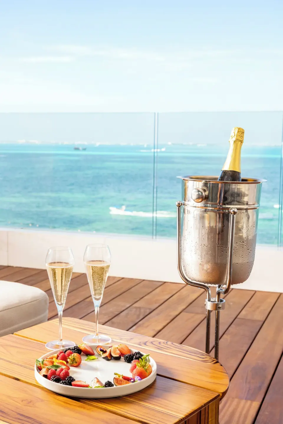 Sparkling wine, fruit, and ocean view on a terrace at Hotel Mousai Cancun.