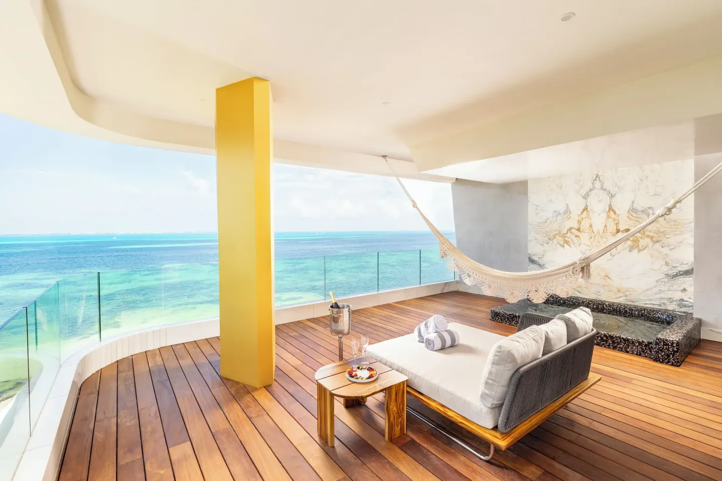 Corner Suite Ocean Front terrace with daybed and hammock at Hotel Mousai Cancun.