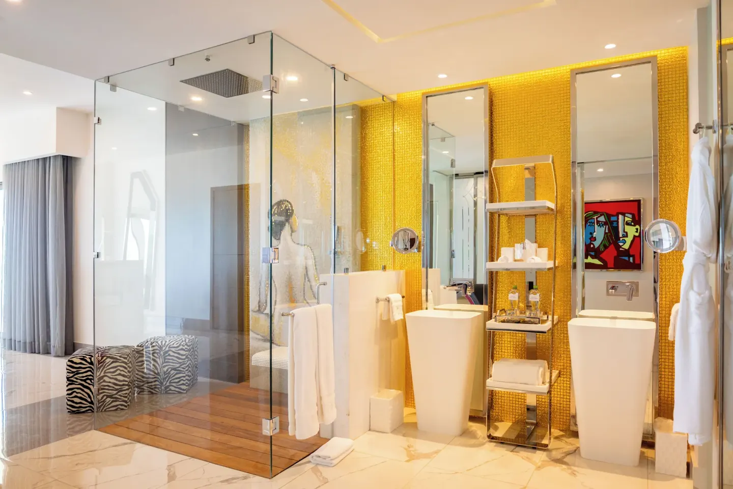 Suite Ocean Front bathroom with glass shower and gold wall at Hotel Mousai Cancun.