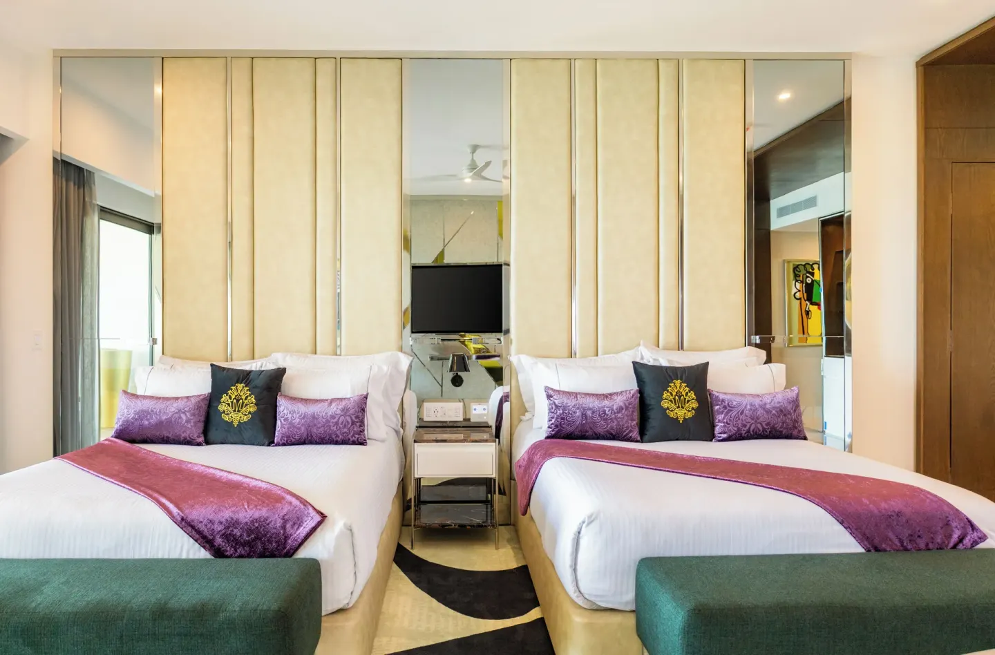Suite ocean front room with two beds and mirrored headboard at Hotel Mousai Cancun.