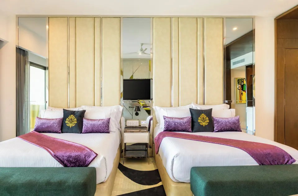 Suite ocean front room with two beds and mirrored headboard at Hotel Mousai Cancun.