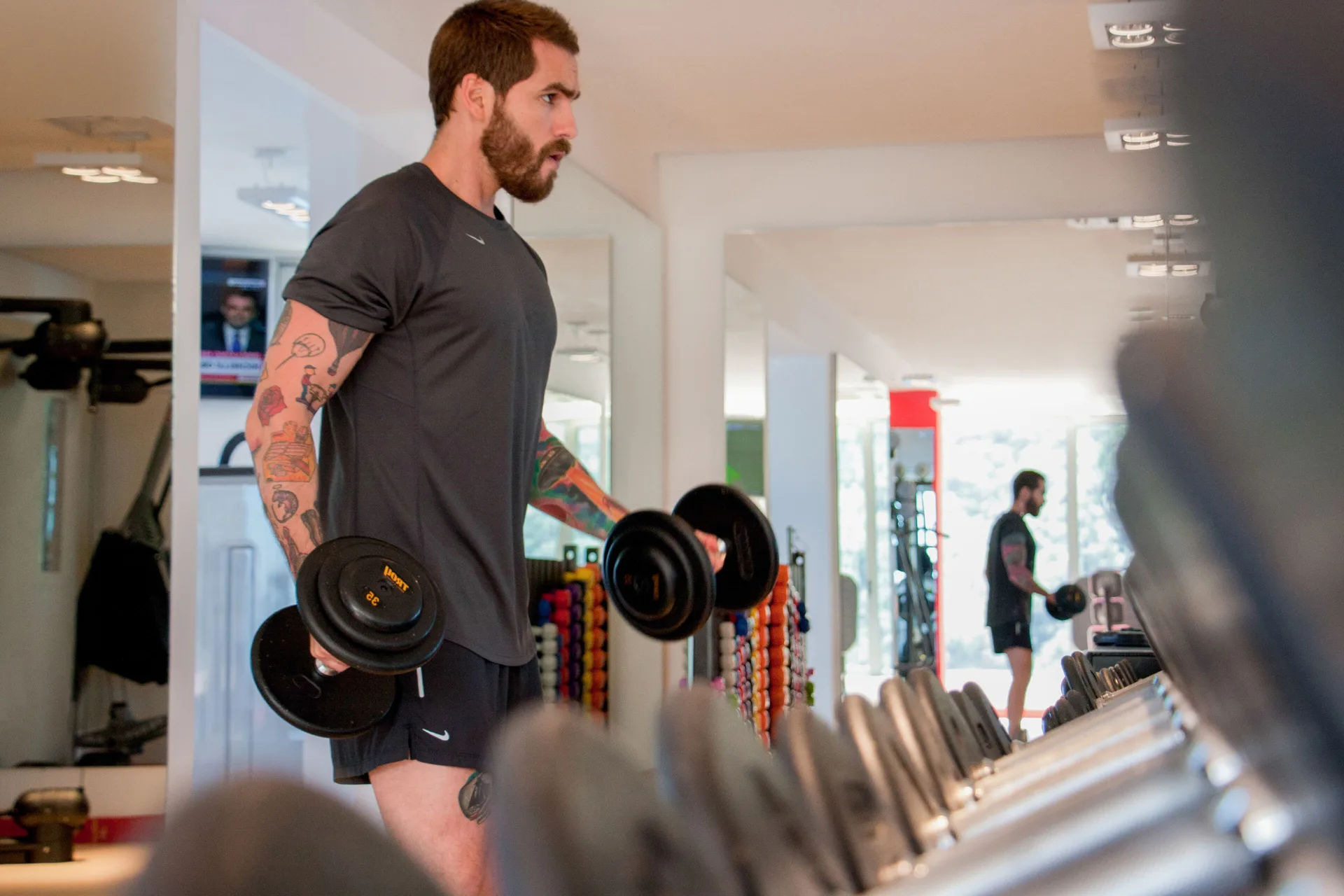 Guest lifting dumbbells in the fitness center at Hotel Mousai Puerto Vallarta.