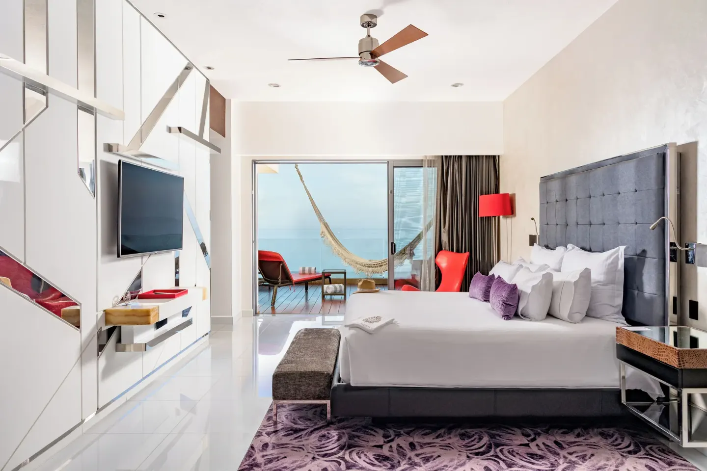 King bed guest room with ocean-facing balcony hammock at Hotel Mousai Puerto Vallarta.