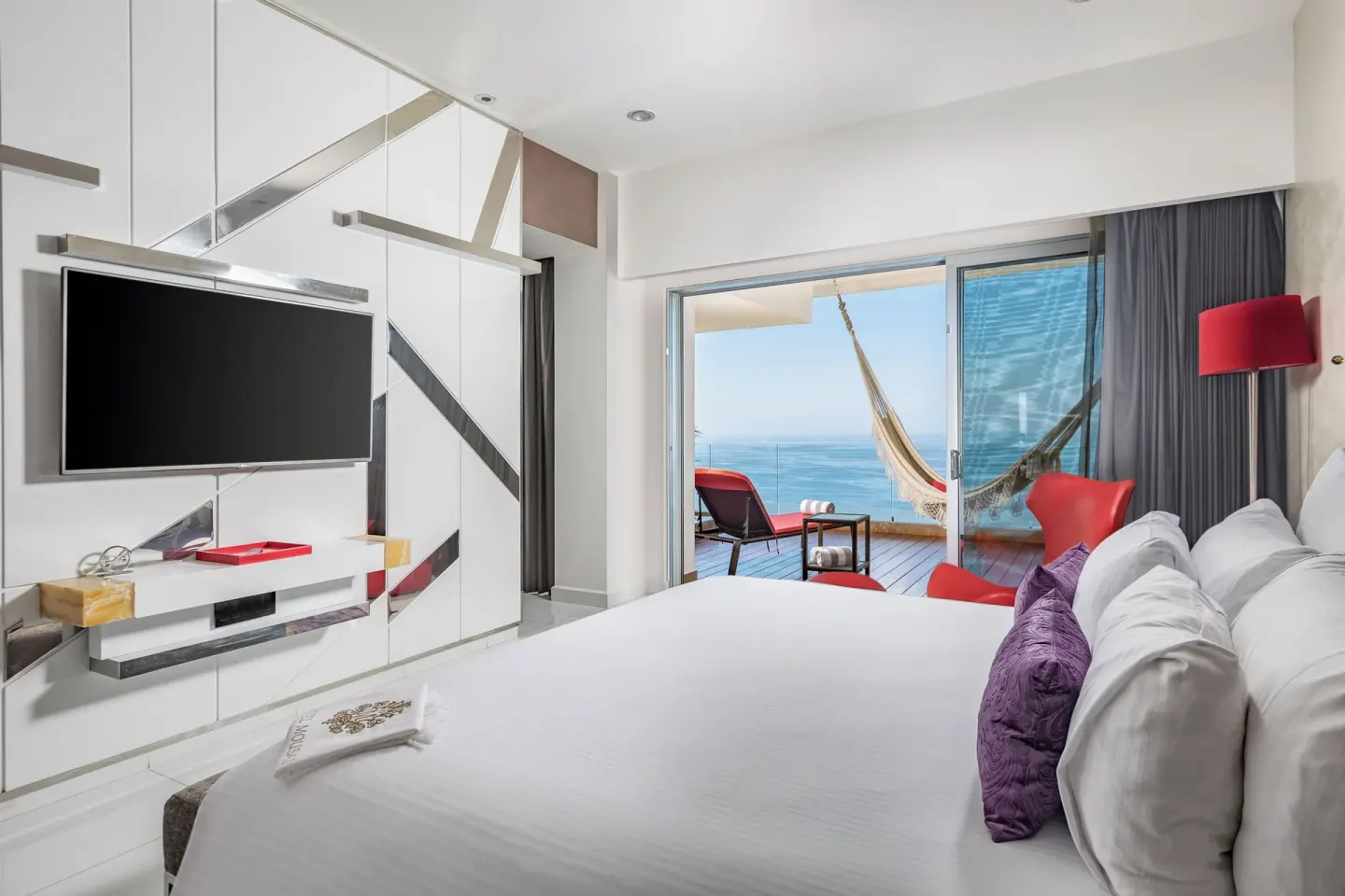 King bed guest room with balcony hammock and sea view at Hotel Mousai Puerto Vallarta.