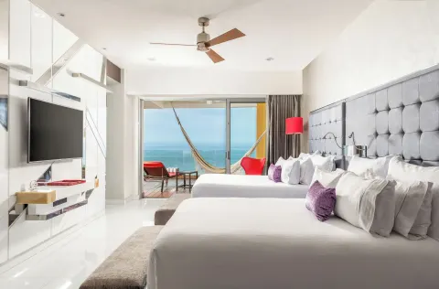 Two bed guest room with ocean-view balcony and hammock at Hotel Mousai Puerto Vallarta.