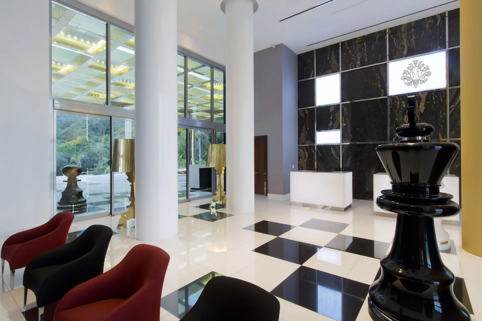 Lobby seating, chess piece sculpture, and front desk at Hotel Mousai Puerto Vallarta.