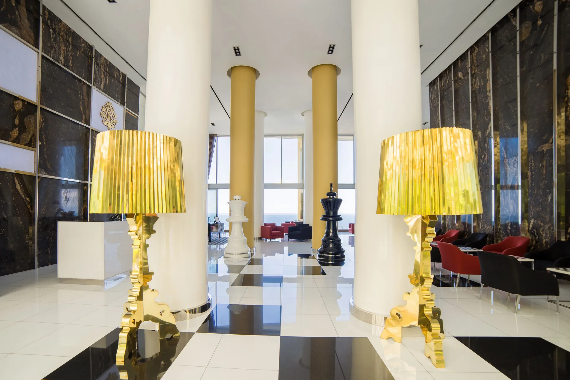 Lobby corridor with gold lamps and chess pieces at Hotel Mousai Puerto Vallarta.