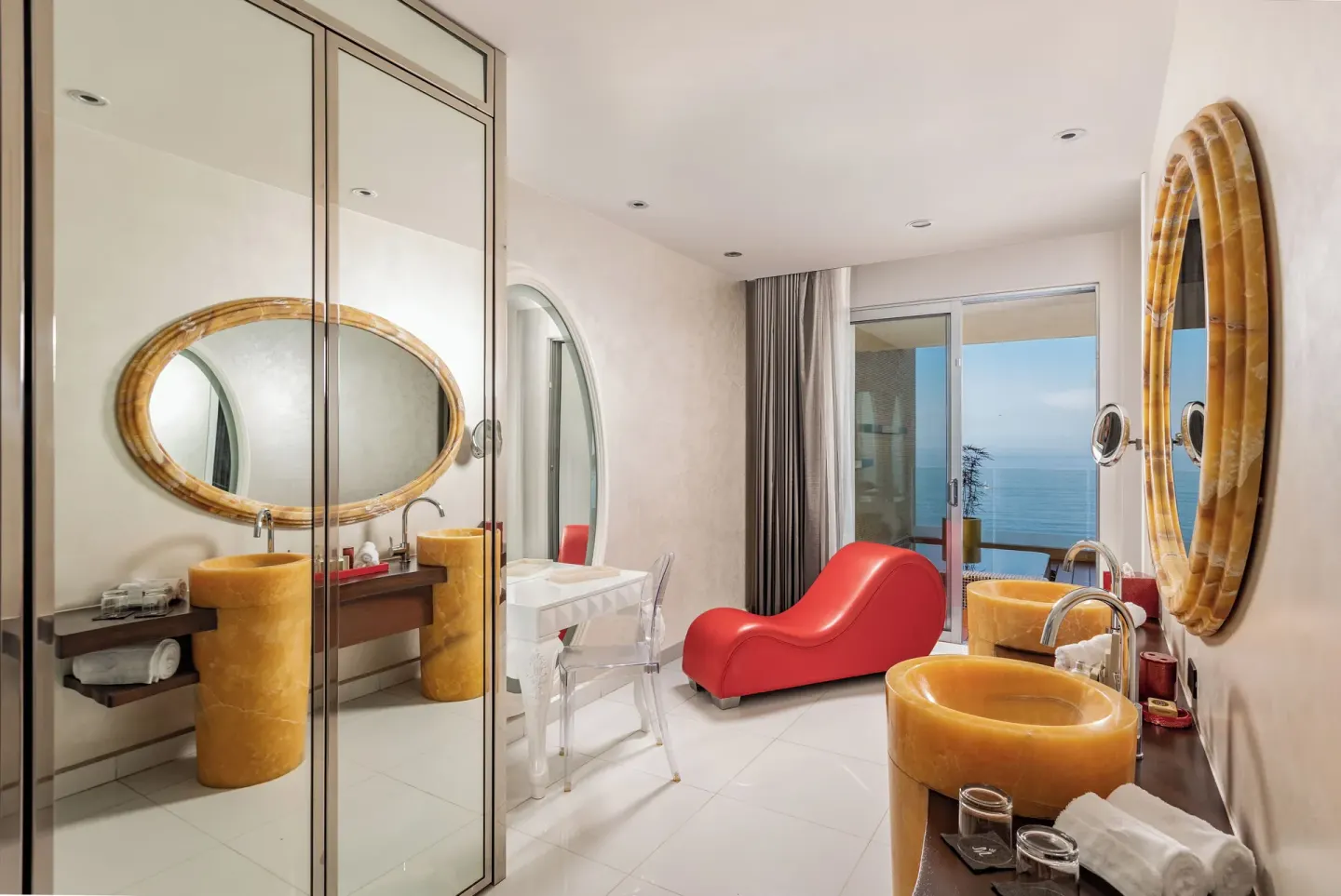 Bathroom with yellow stone sinks and ocean-view balcony at Hotel Mousai Puerto Vallarta.