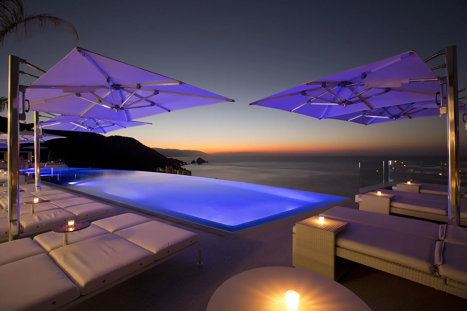 Rooftop infinity pool with loungers and sunset view at Hotel Mousai Puerto Vallarta.