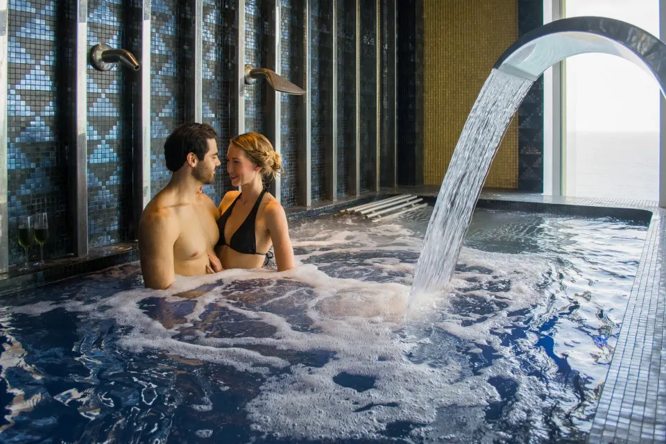 Couple relaxing in a bubbling spa pool at Hotel Mousai Puerto Vallarta.