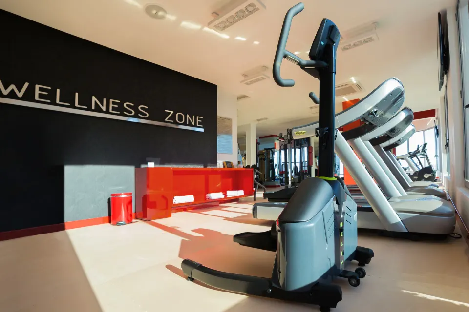 Fitness center with cardio machines and Wellness Zone wall at Hotel Mousai Puerto Vallarta.