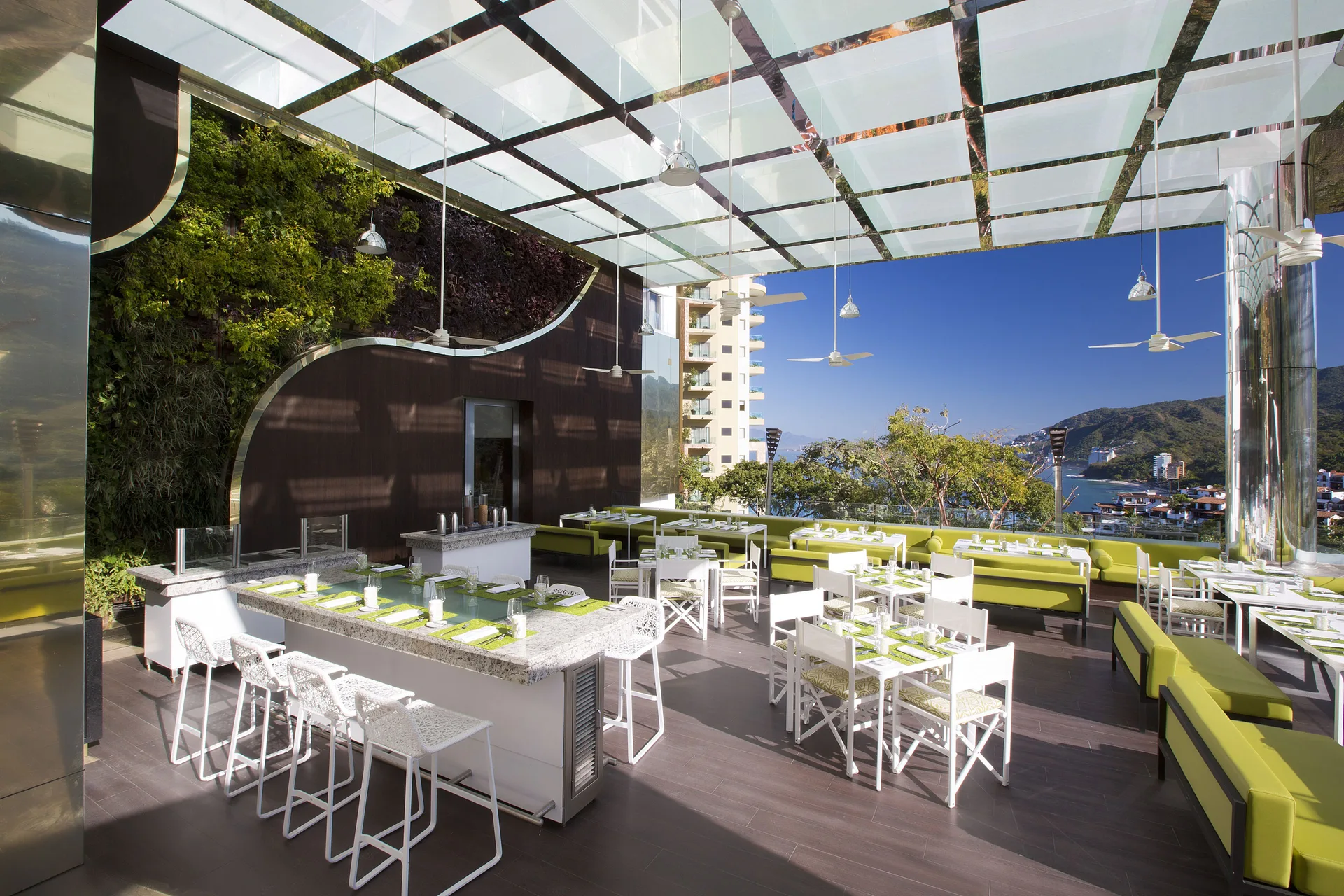 Open-air rooftop lounge with green seating at Hotel Mousai Puerto Vallarta.