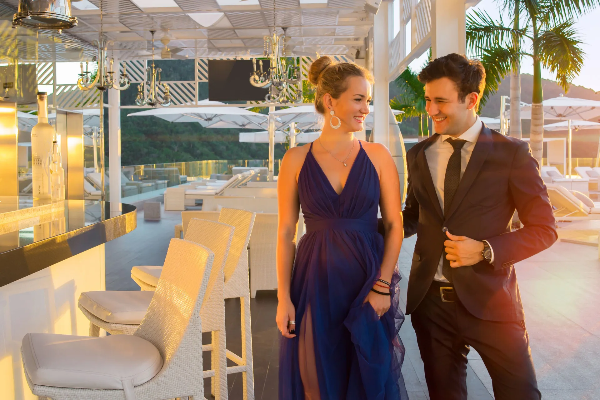 A couple walks beside a rooftop bar at sunset at Hotel Mousai Puerto Vallarta.