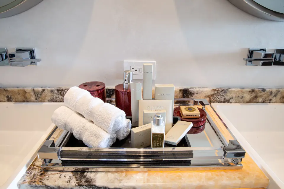 Corner Suite bathroom tray with towels and bath amenities at Hotel Mousai Puerto Vallarta.