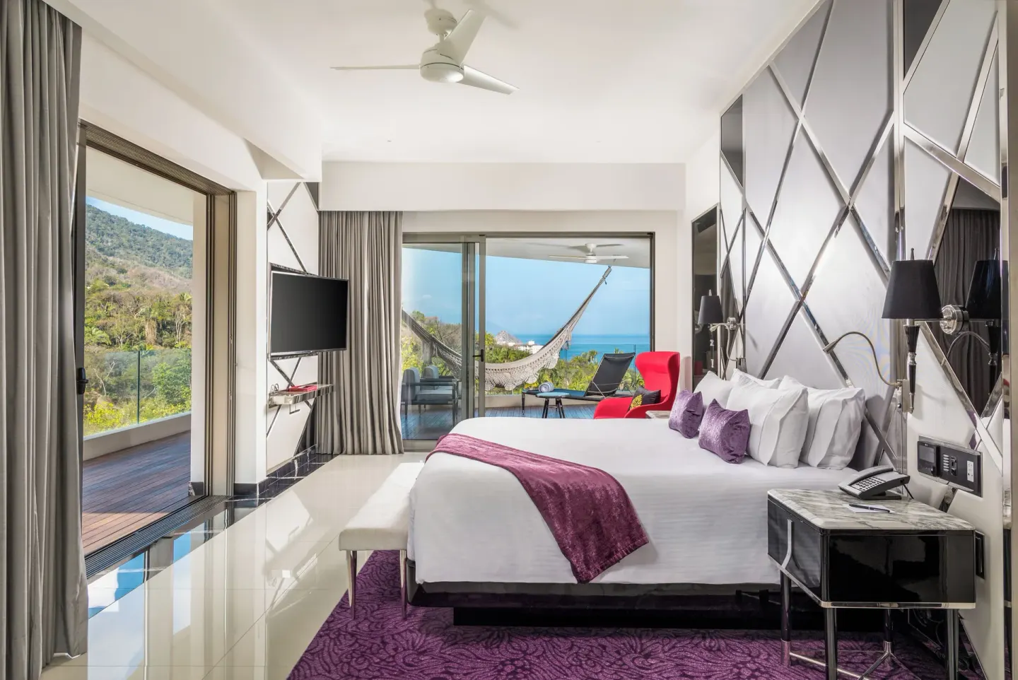 Corner Suite king bed and balcony with ocean view at Hotel Mousai Puerto Vallarta.