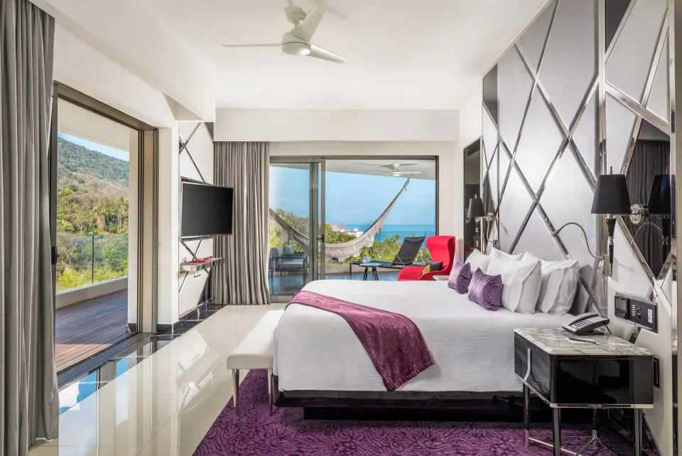 Corner Suite king bed and balcony with ocean view at Hotel Mousai Puerto Vallarta.