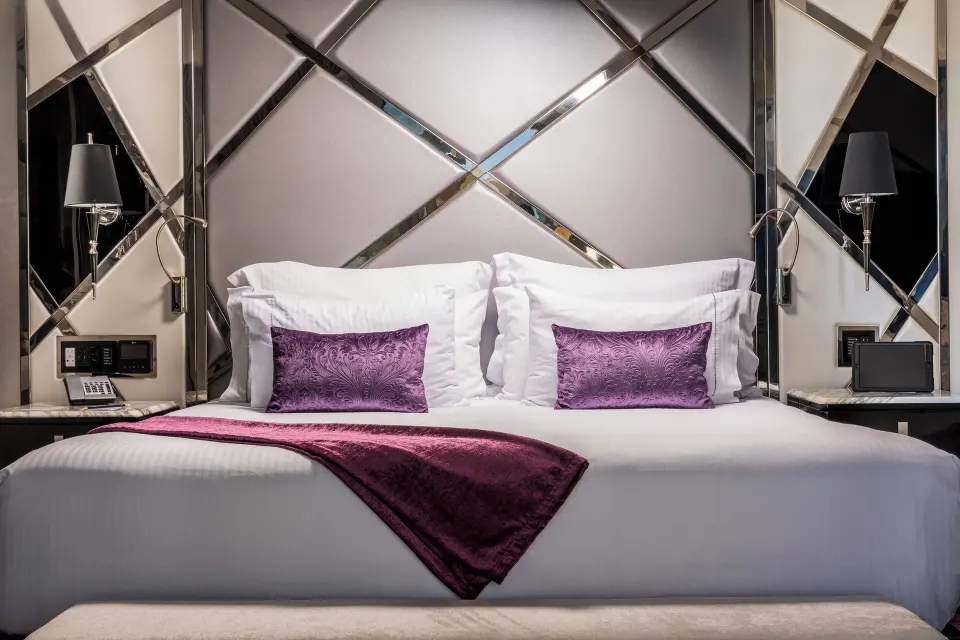 Corner Suite king bed with mirrored headboard at Hotel Mousai Puerto Vallarta.