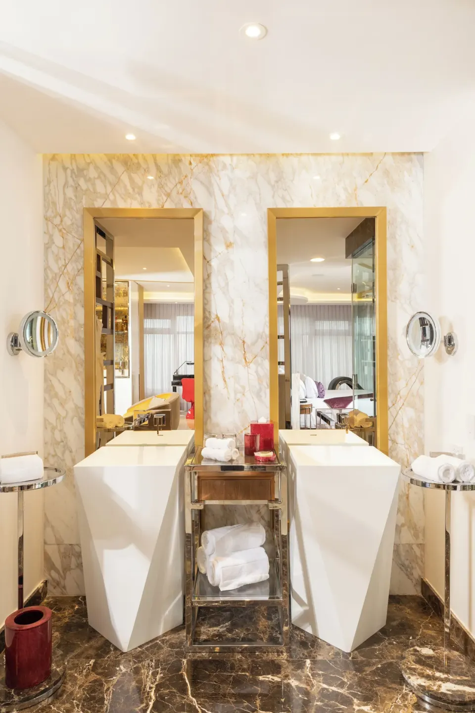 Master Suite bathroom twin sinks with gold mirrors and marble wall at Hotel Mousai Puerto Vallarta.