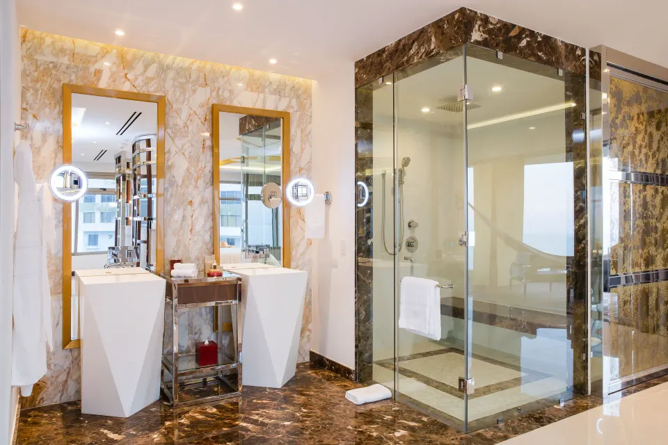 Master Suite bathroom with twin vanities and glass shower at Hotel Mousai Puerto Vallarta.