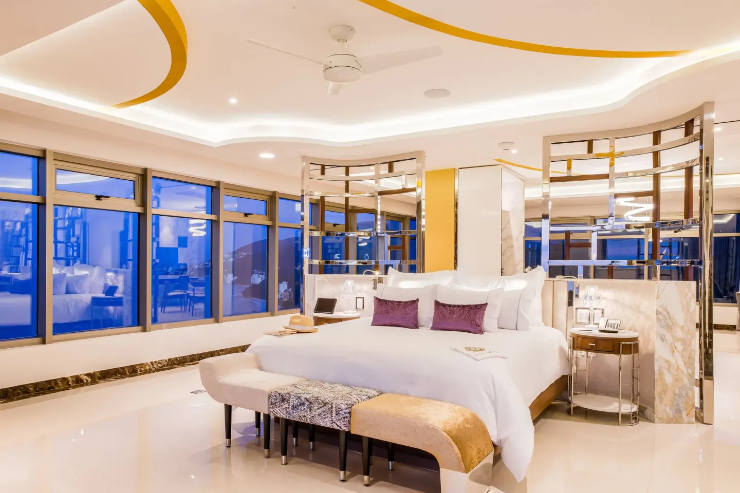 Master Suite king bed with mirrored panels and blue evening windows at Hotel Mousai Puerto Vallarta.