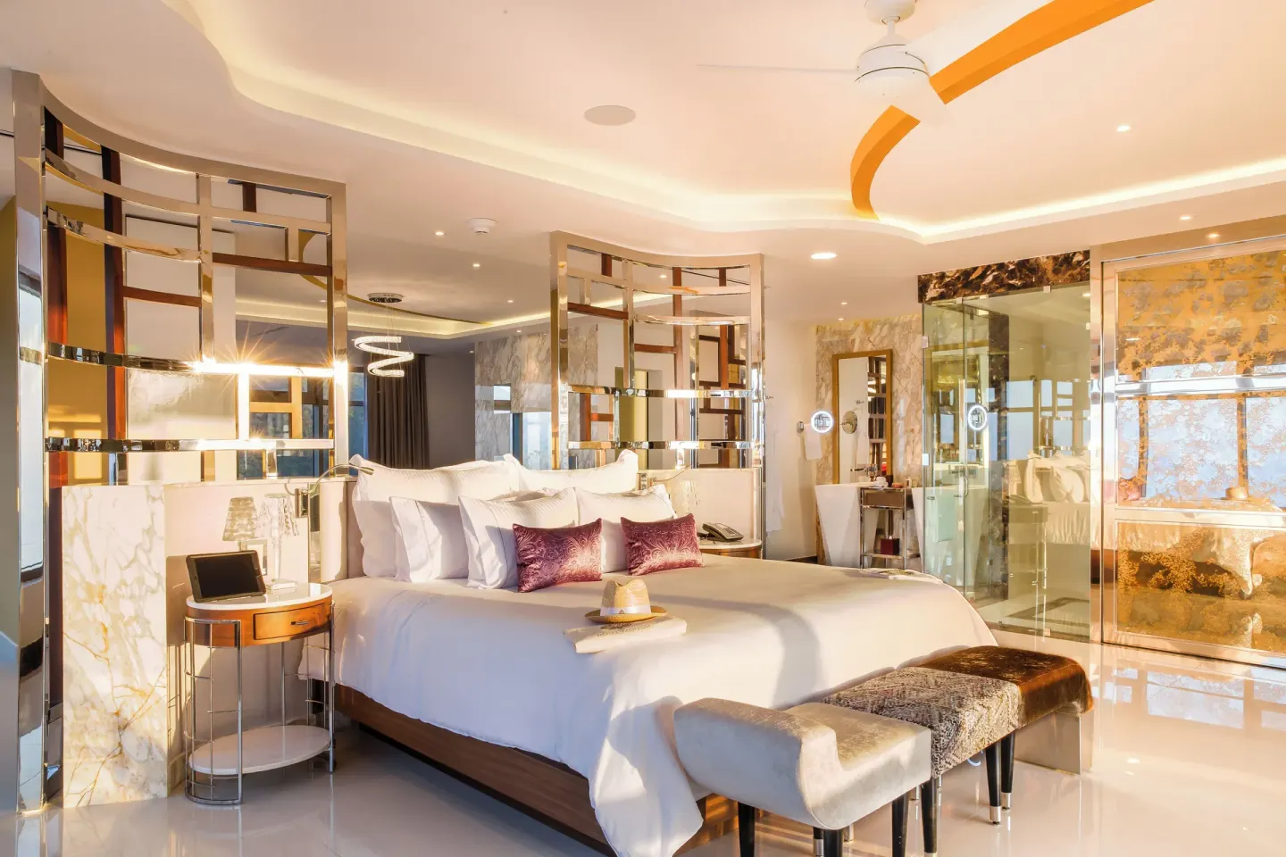 Master Suite king bed with open glass bathroom and gold ceiling detail at Hotel Mousai Puerto Vallarta.