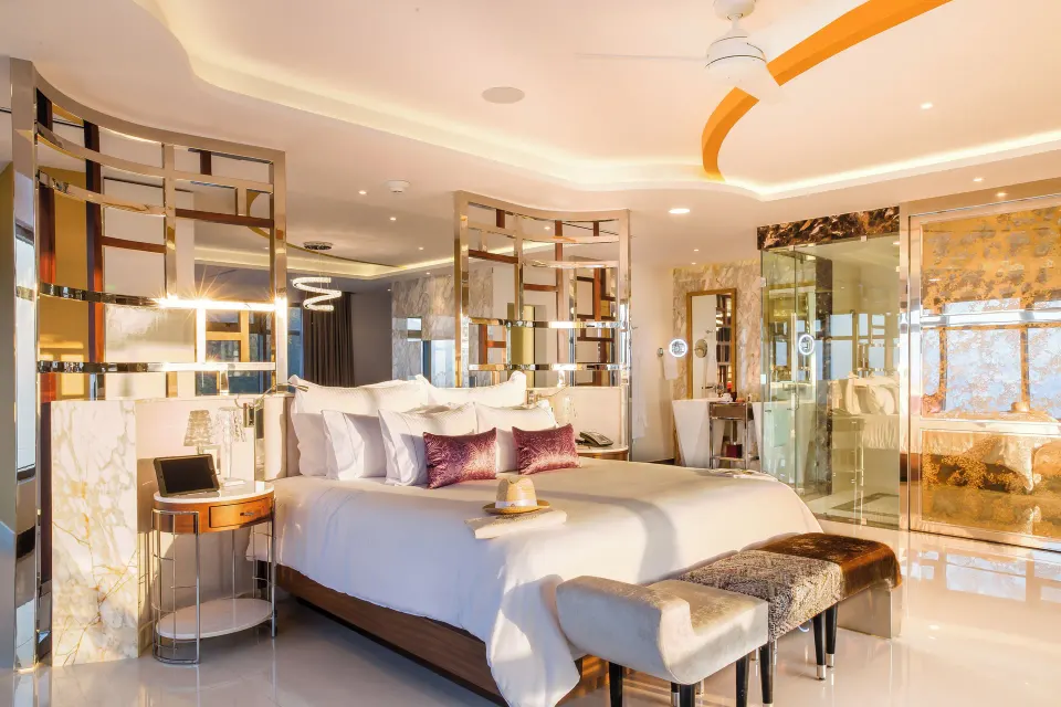 Master Suite king bed with open glass bathroom and gold ceiling detail at Hotel Mousai Puerto Vallarta.