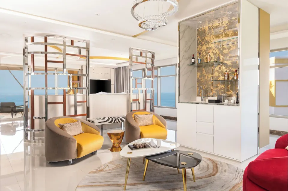 Master Suite lounge with yellow chairs, cocktail tables, and ocean views at Hotel Mousai Puerto Vallarta.