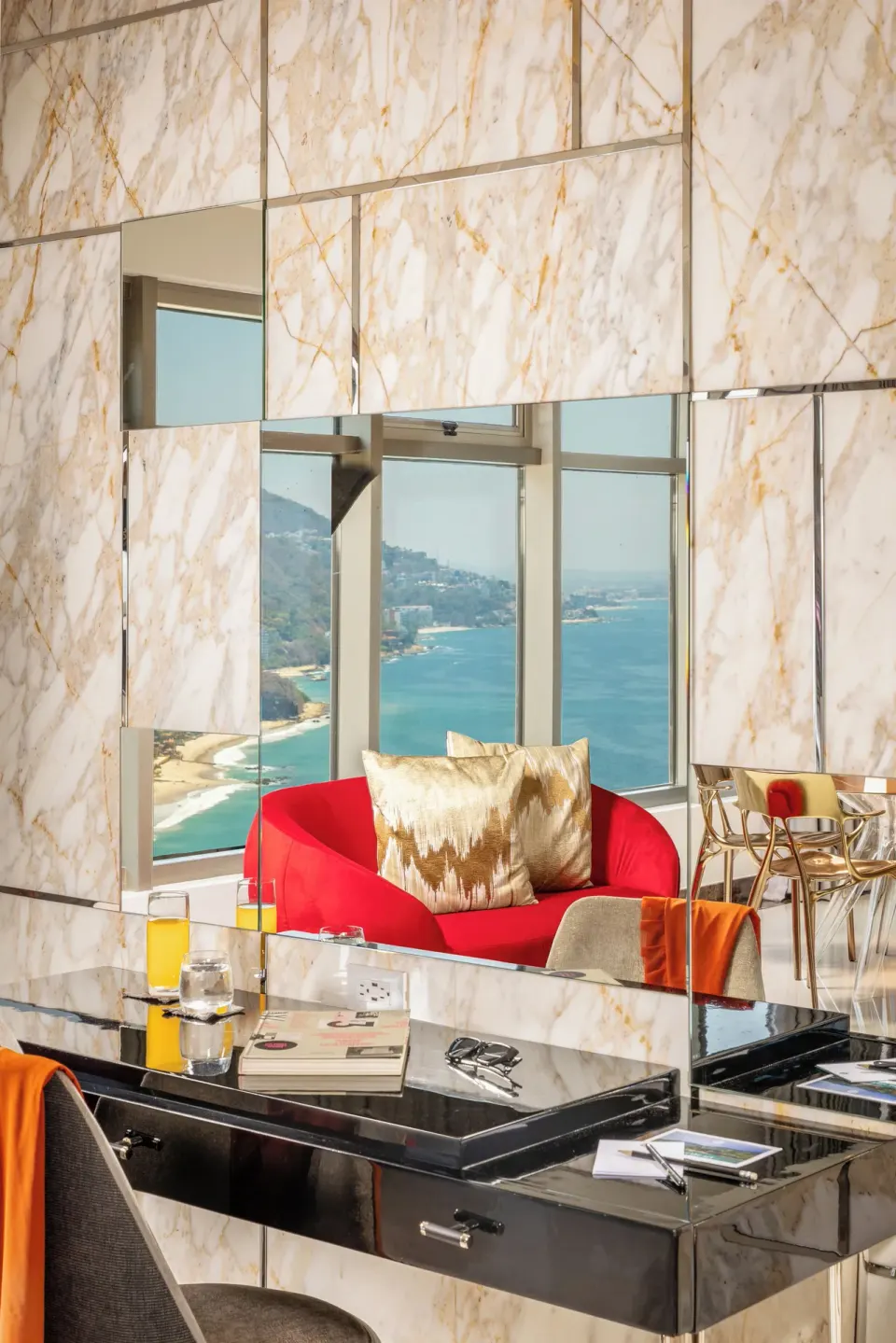 Master Suite vanity desk and red lounge chair with ocean view at Hotel Mousai Puerto Vallarta.