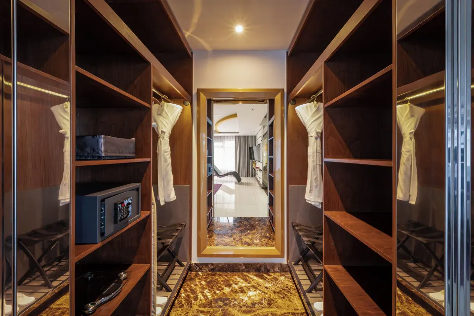 Master Suite walk-in closet with wood shelving, robes, and safe at Hotel Mousai Puerto Vallarta.