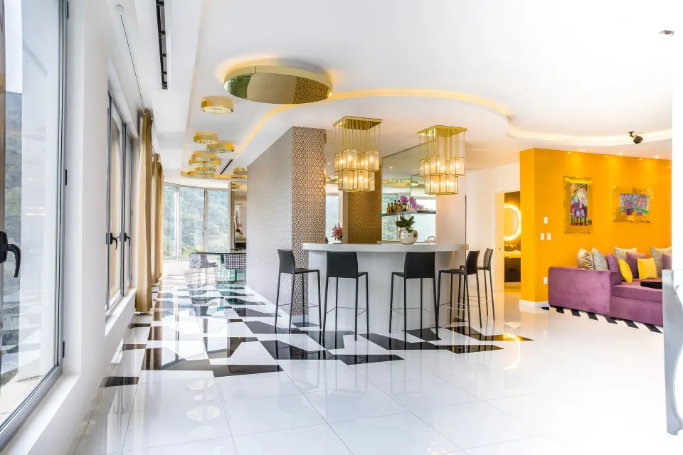 Bar and lounge area in The Penthouse at Hotel Mousai Puerto Vallarta with bright yellow accents.