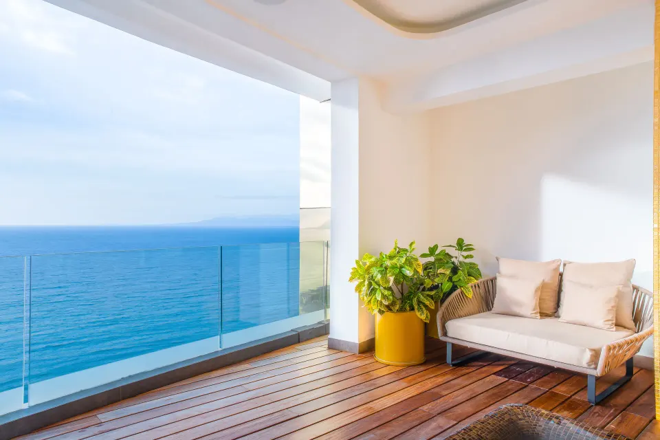 The Penthouse terrace at Hotel Mousai Puerto Vallarta with ocean view, sofa seating, and potted greenery.