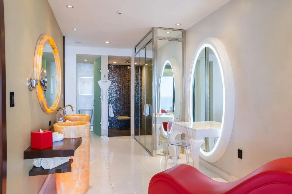 Bathroom vanity and lounge chair in a Two Bedroom Suite Connected at Hotel Mousai Puerto Vallarta.
