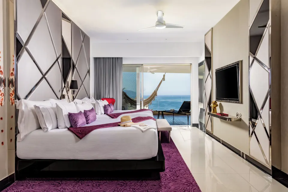 Ultra Two Bedroom Suite bedroom with ocean-facing balcony at Hotel Mousai Puerto Vallarta.