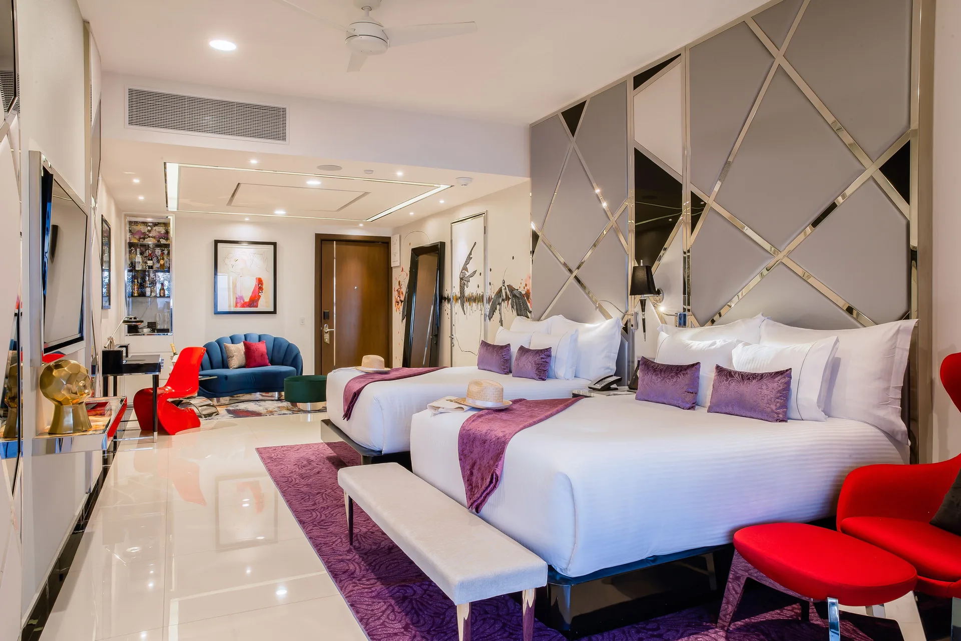 Ultra guest room with two white beds and colorful seating at Hotel Mousai Puerto Vallarta.