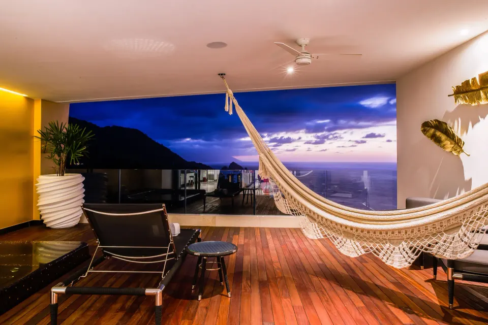 Ultra room balcony with hammock, loungers, and ocean view at Hotel Mousai Puerto Vallarta.