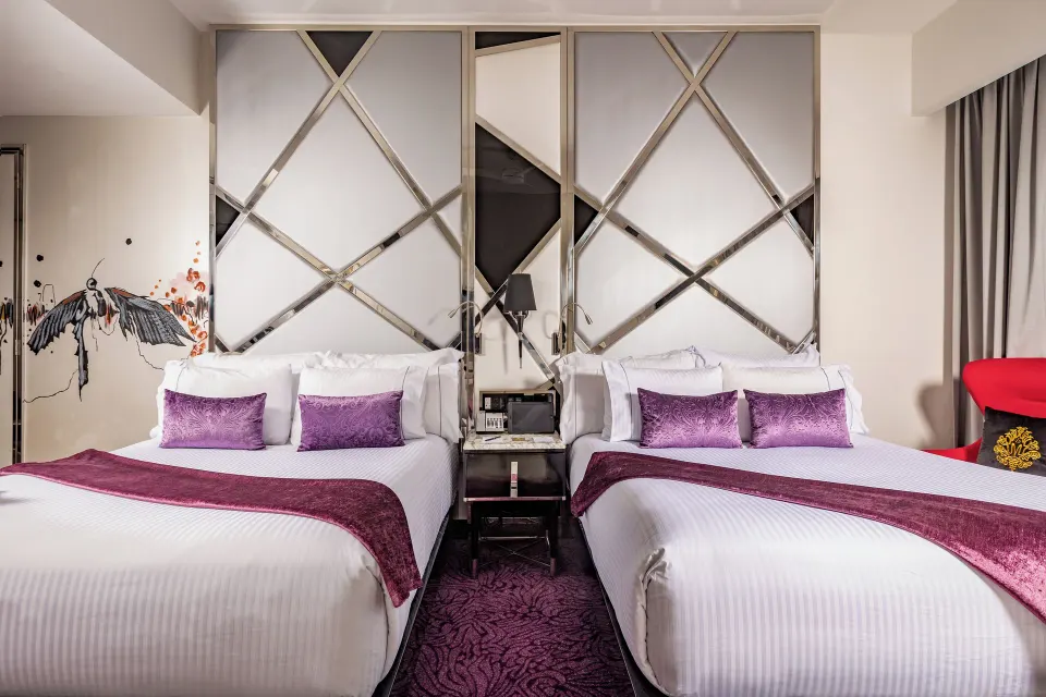 Ultra room with two beds and purple accents at Hotel Mousai Puerto Vallarta.