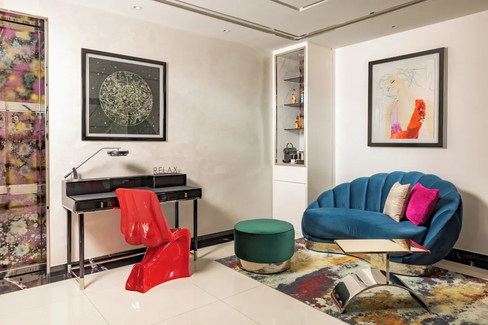 Ultra suite sitting area with blue sofa and red chair at Hotel Mousai Puerto Vallarta.