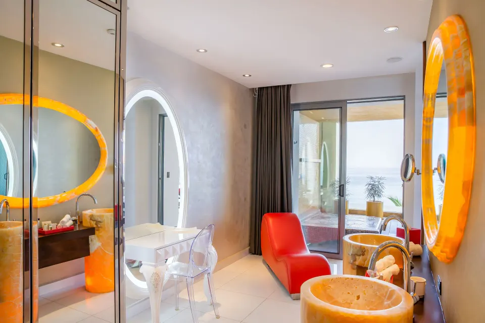 Ultra suite vanity area with orange mirrors and terrace doors at Hotel Mousai Puerto Vallarta.