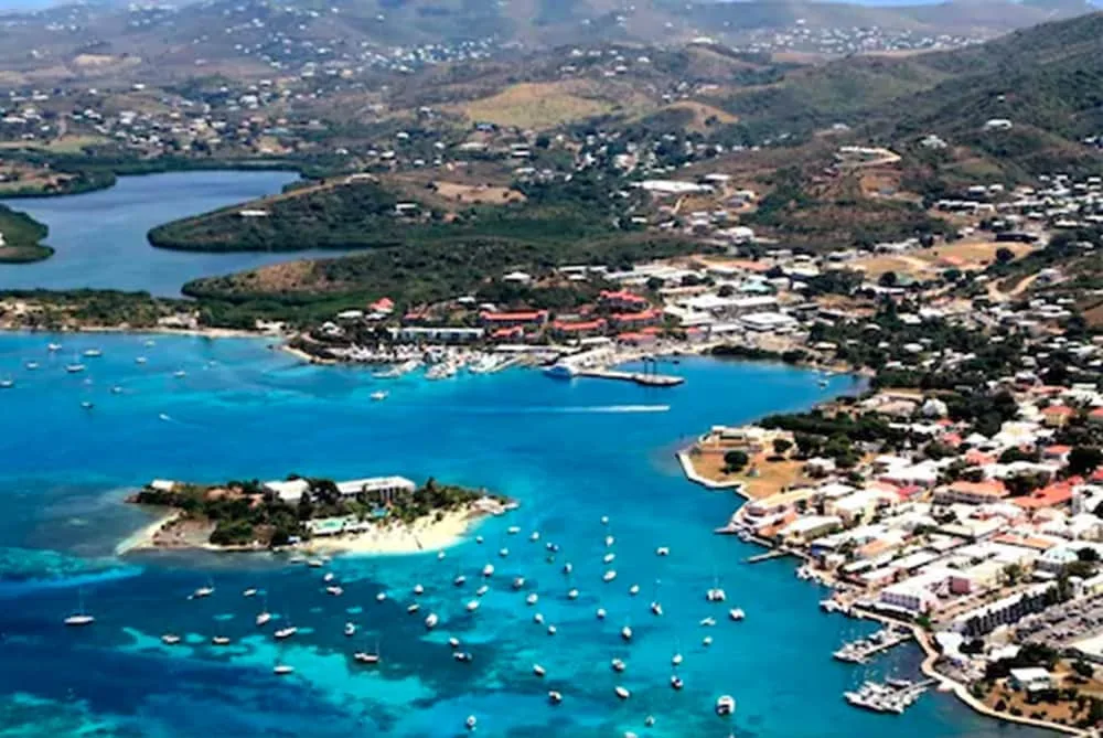 Aerial harbor view with Hotel on the Cay island near town and moored boats.