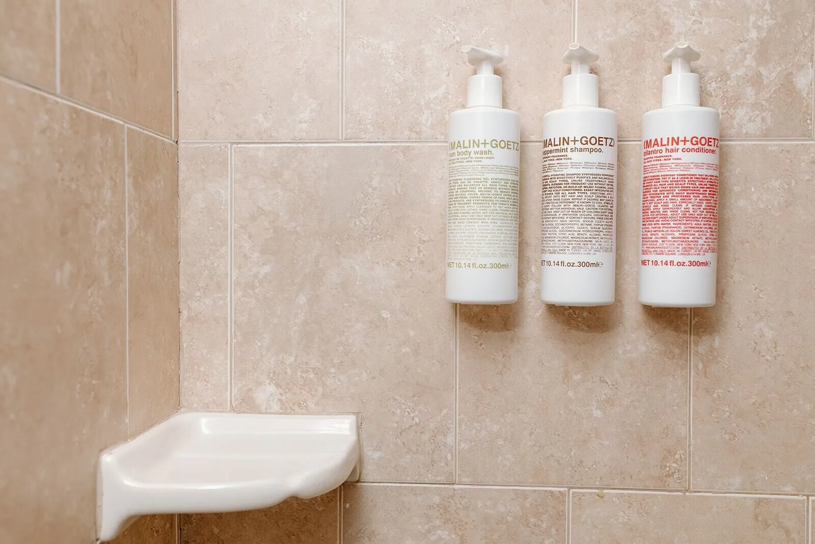 Shower dispensers and soap dish in a tiled bathroom at Hotel on the Cay.