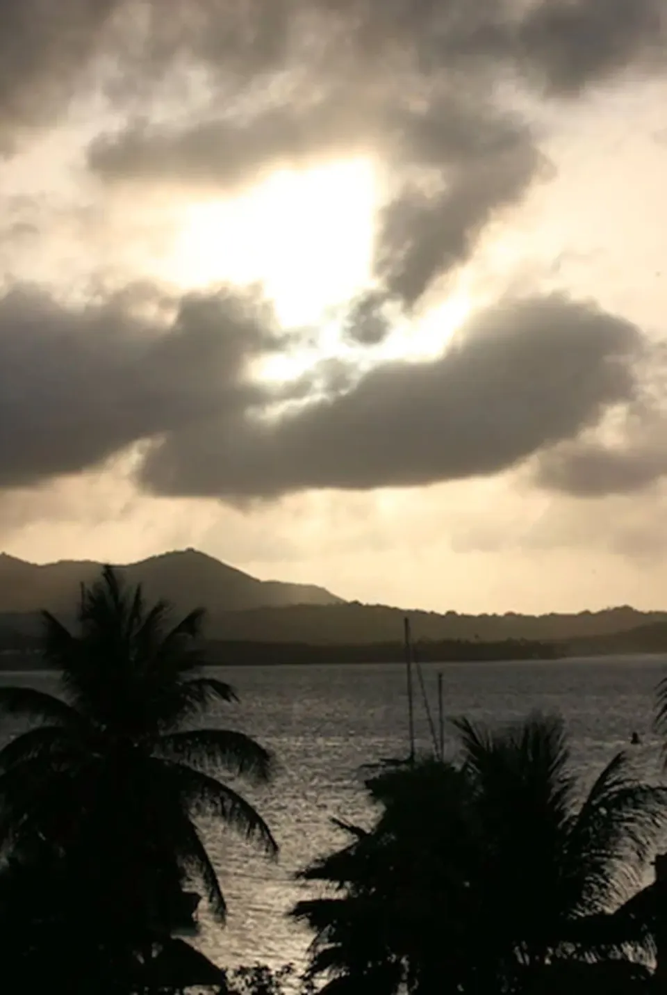 Dramatic cloudy sky over the water and palms at Hotel on the Cay.