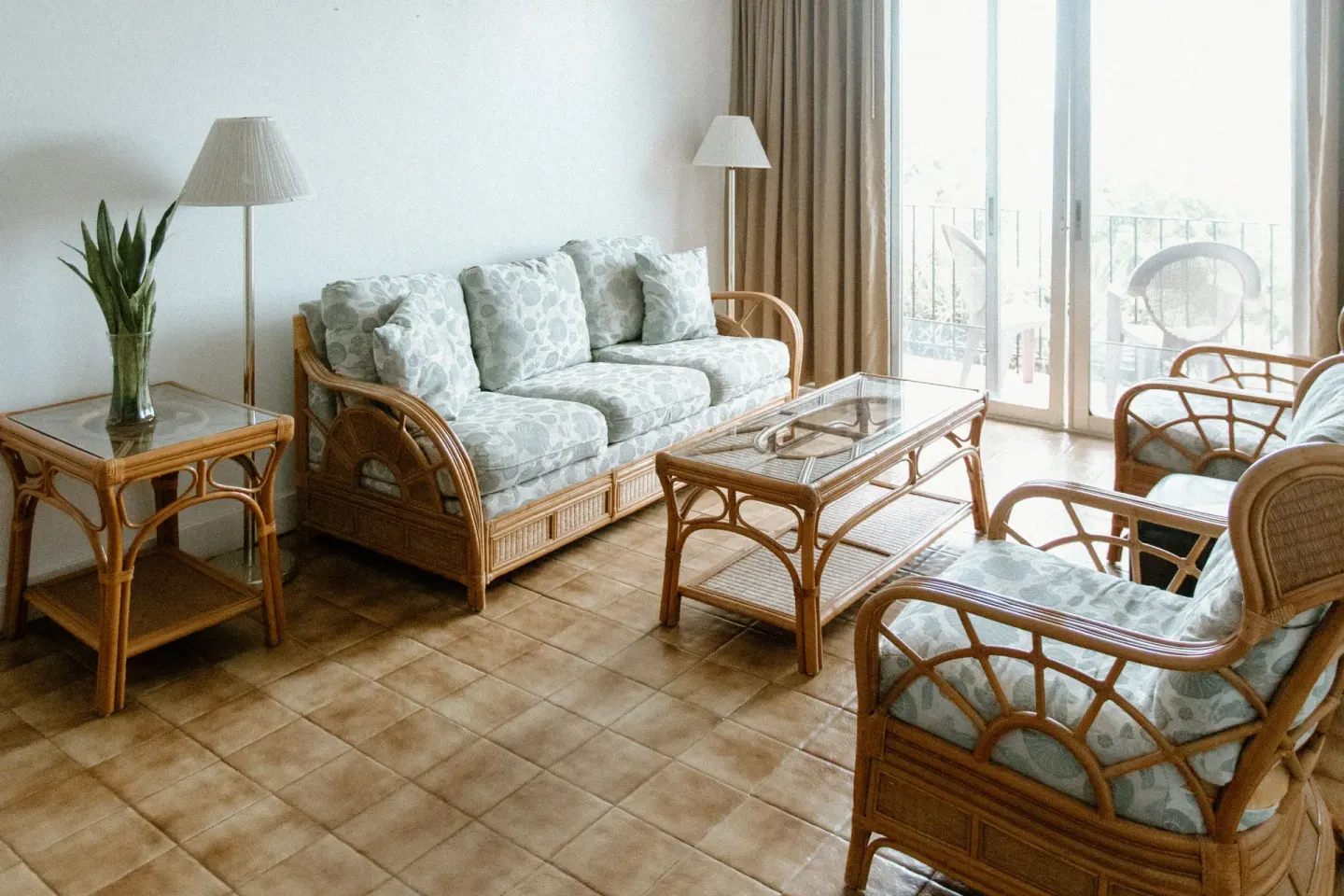 Rattan sofa, armchairs, and glass tables in a sitting area at Hotel on the Cay.
