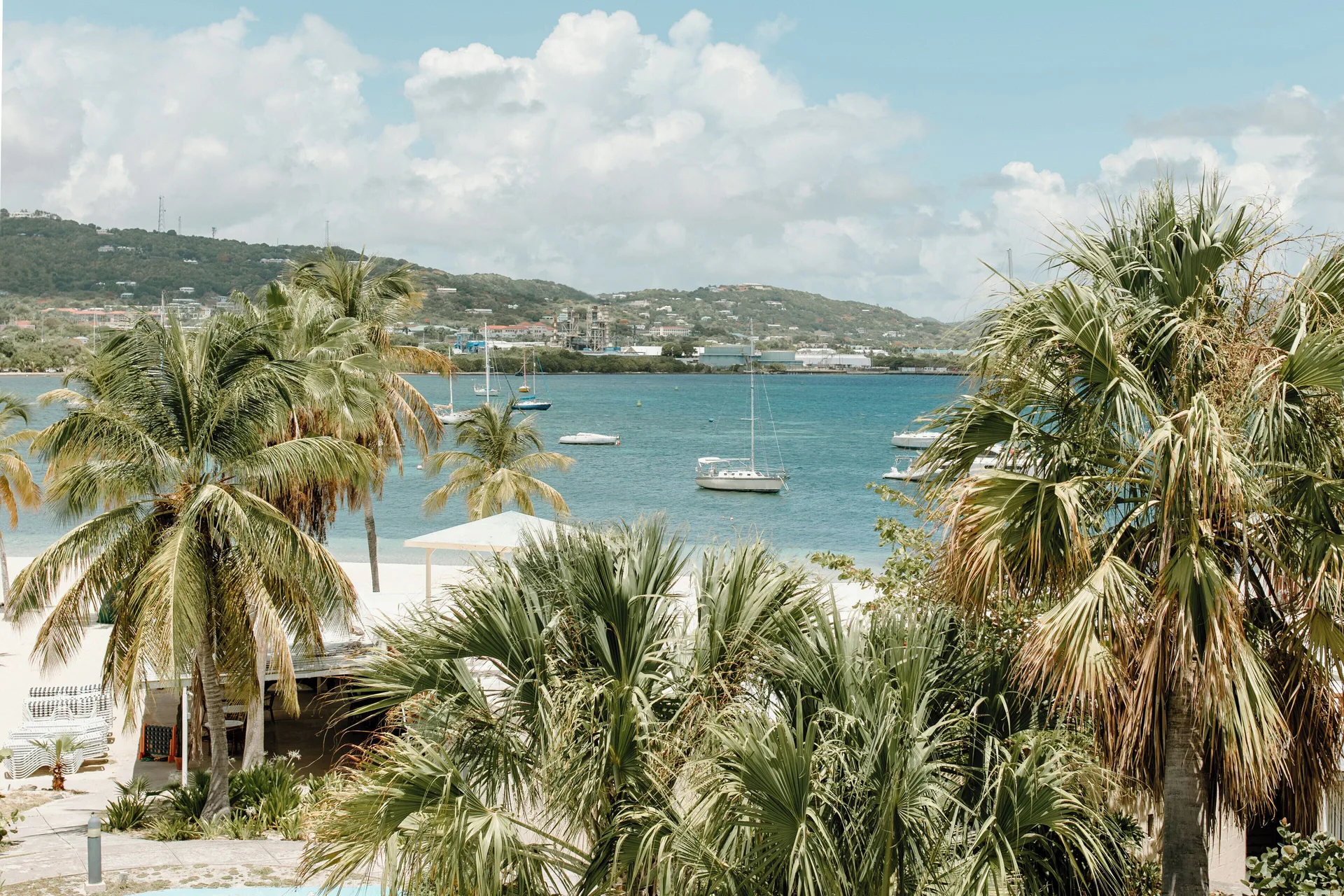 Palm-framed harbor and beach view at Hotel on the Cay.